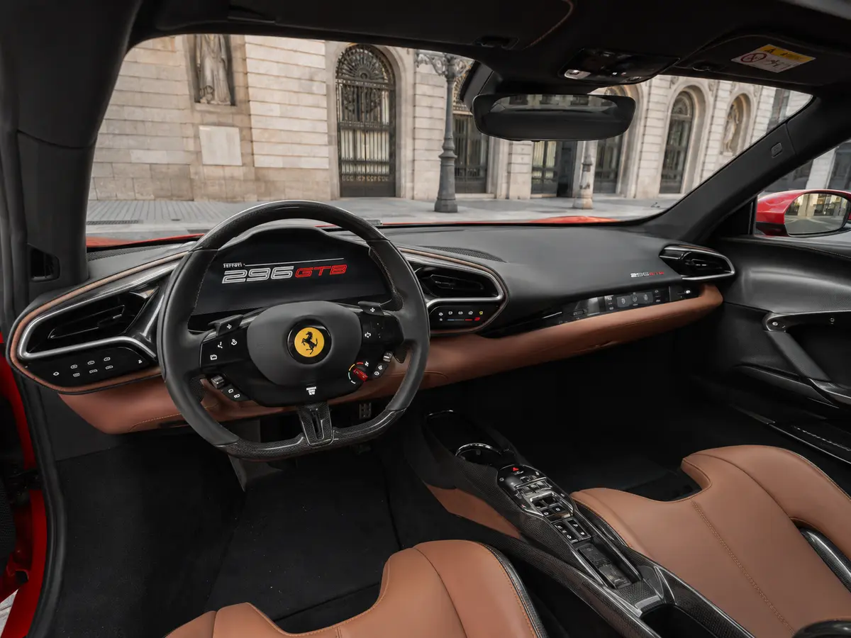 Ferrari 296 GTB 2023, interior — Lisbon Luxury Car Rental, Lisbon. The 296 GTB pairs a twin-turbo V6 with hybrid assistance to reach 830 hp, delivered…