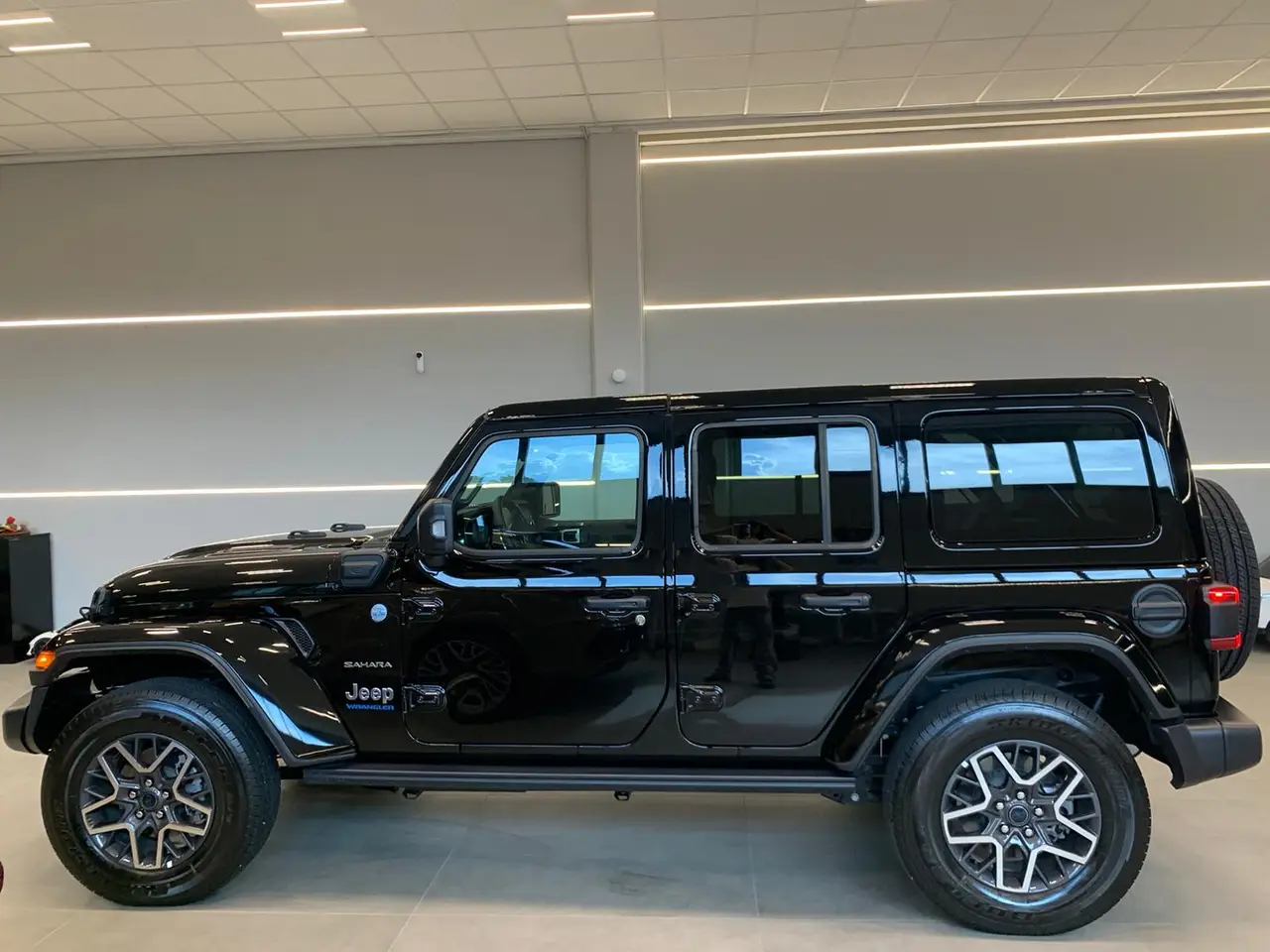 Jeep Wrangler 2025, profil latéral — Lisbon Luxury Car Rental, Lisbonne. Le Jeep Wrangler 2025 impose sa présence dès le premier regard : une silhouette carrée,…